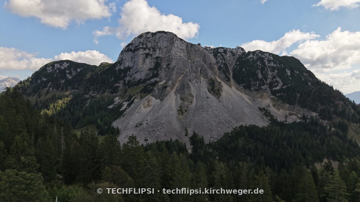 Der Sandling von unten: die Felswand des Berges über dem Nadelwald, fotografiert nach der Tour.